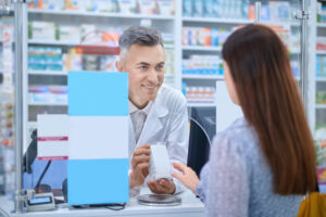 Atendente de farmácia atendendo cliente que deseja comprar um remédio genérico