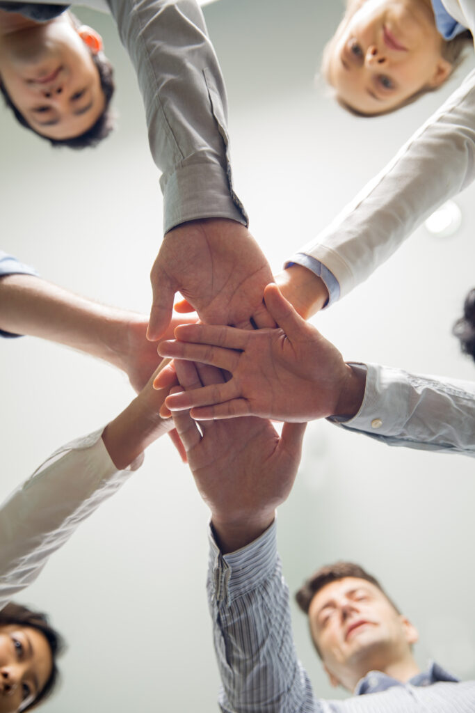 Equipe unida juntando as mãos em sinal de parceria e colaboração no ambiente de trabalho.