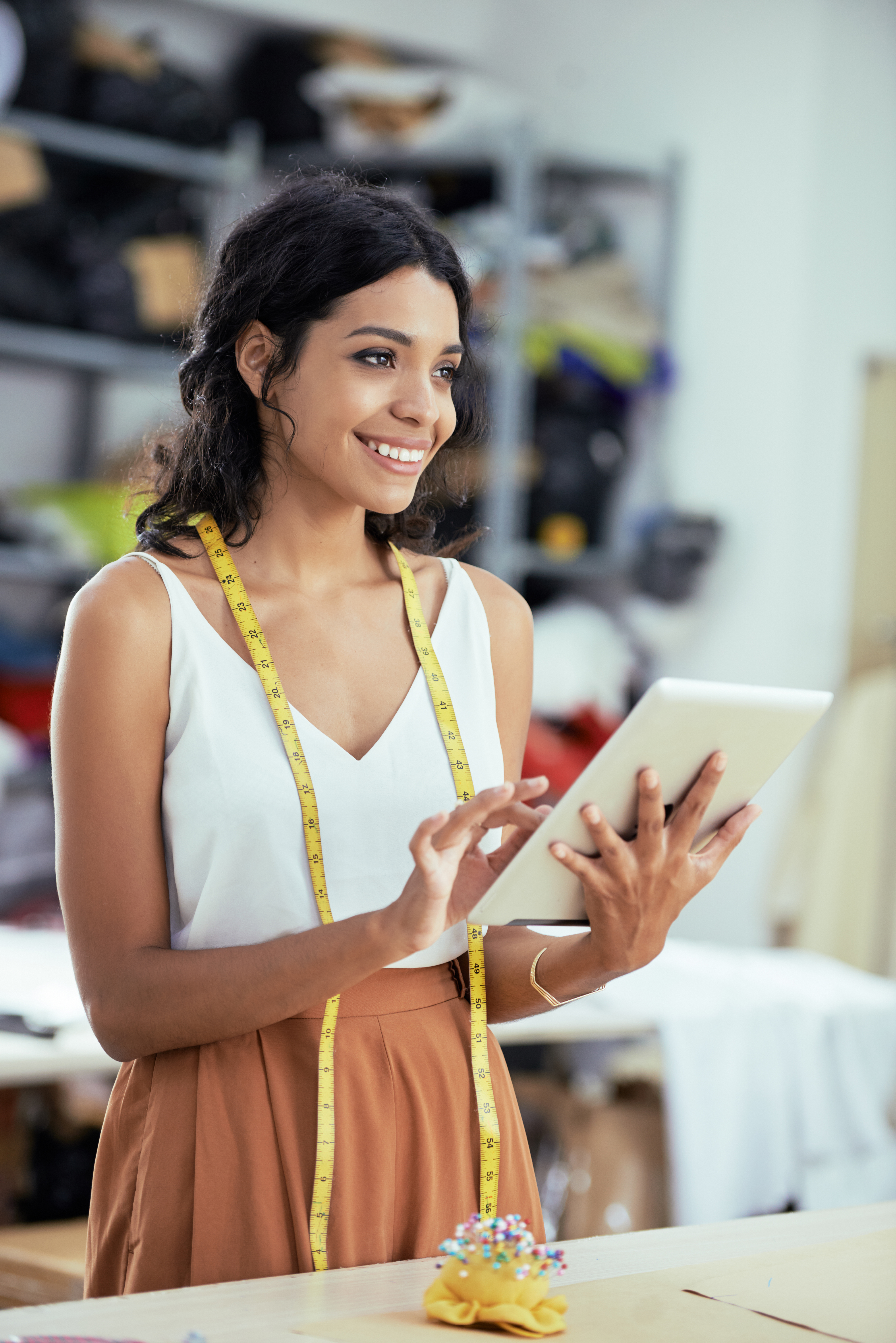 Microempreendedora individual usando tablet em seu ateliê, representando MEIs que economizam ao contratar plano de saúde empresarial da CEDplan em Juiz de Fora.